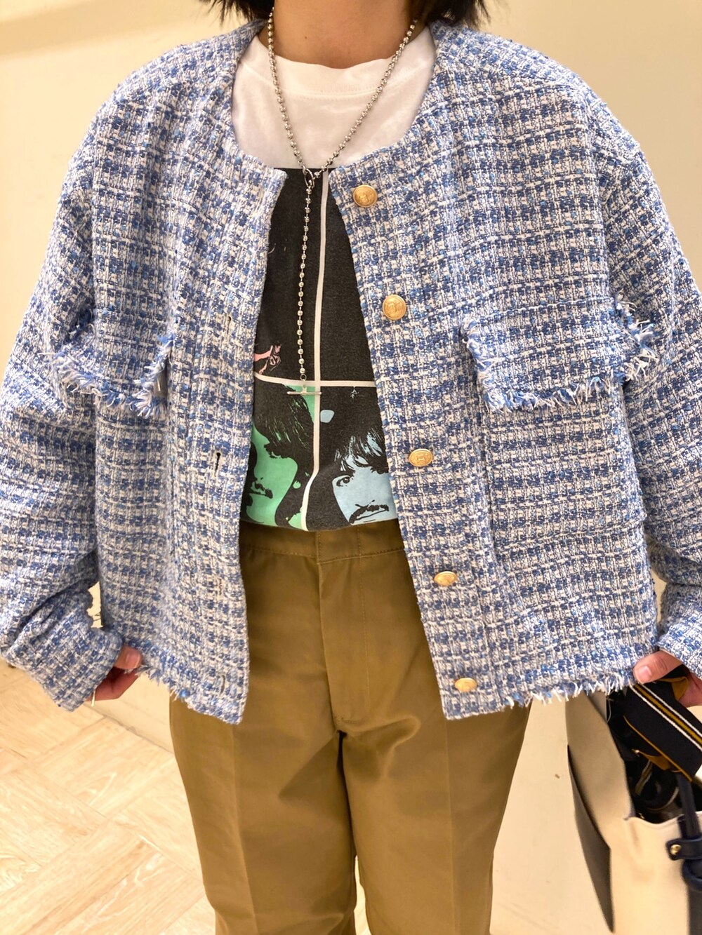 ブルー系のトートバッグ、ベージュ系のその他パンツ、ブルー系のノーカラージャケットを着用したレディースの春コーディネートの4枚目の写真