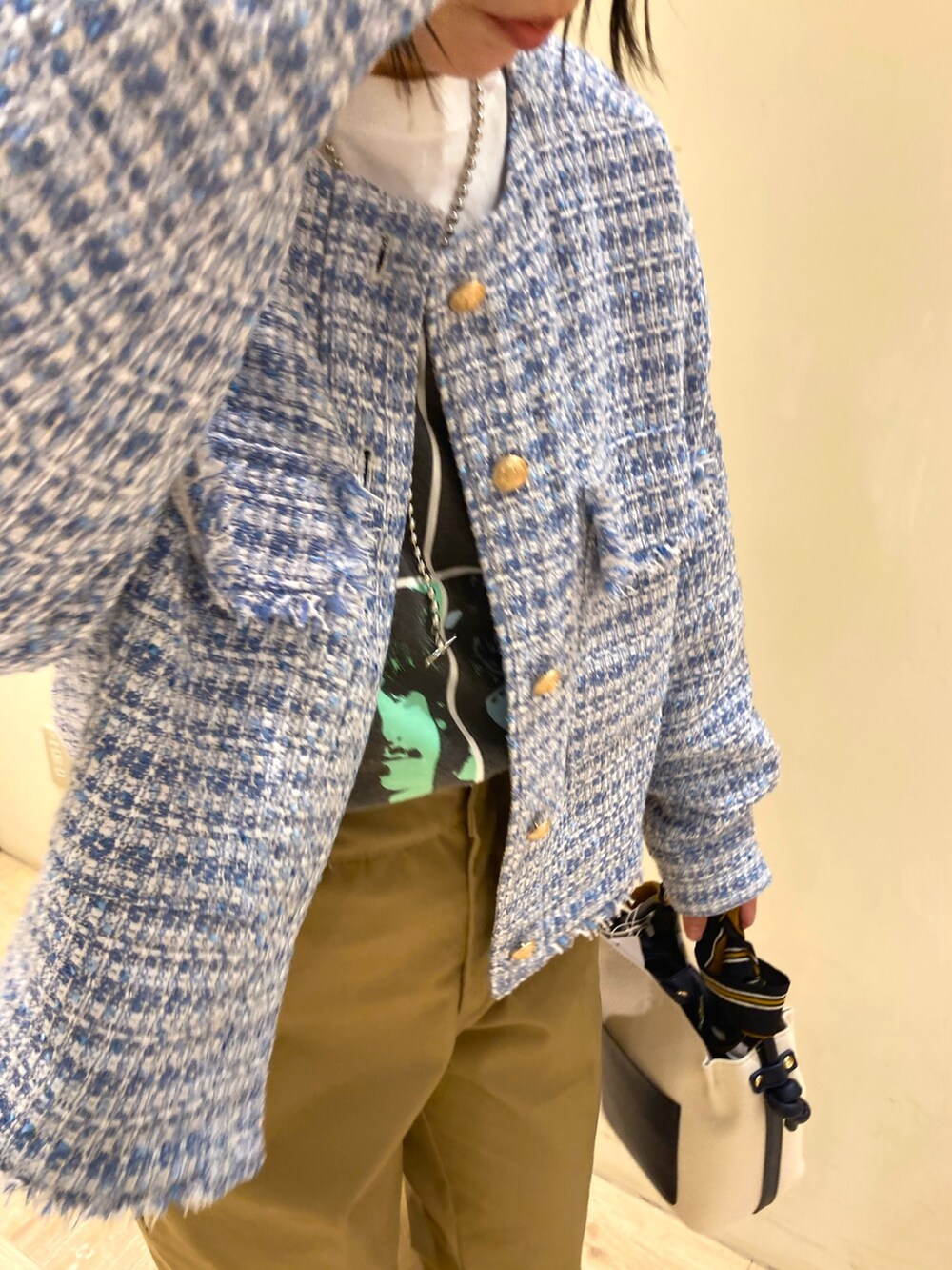 ブルー系のトートバッグ、ベージュ系のその他パンツ、ブルー系のノーカラージャケットを着用したレディースの春コーディネートの2枚目の写真