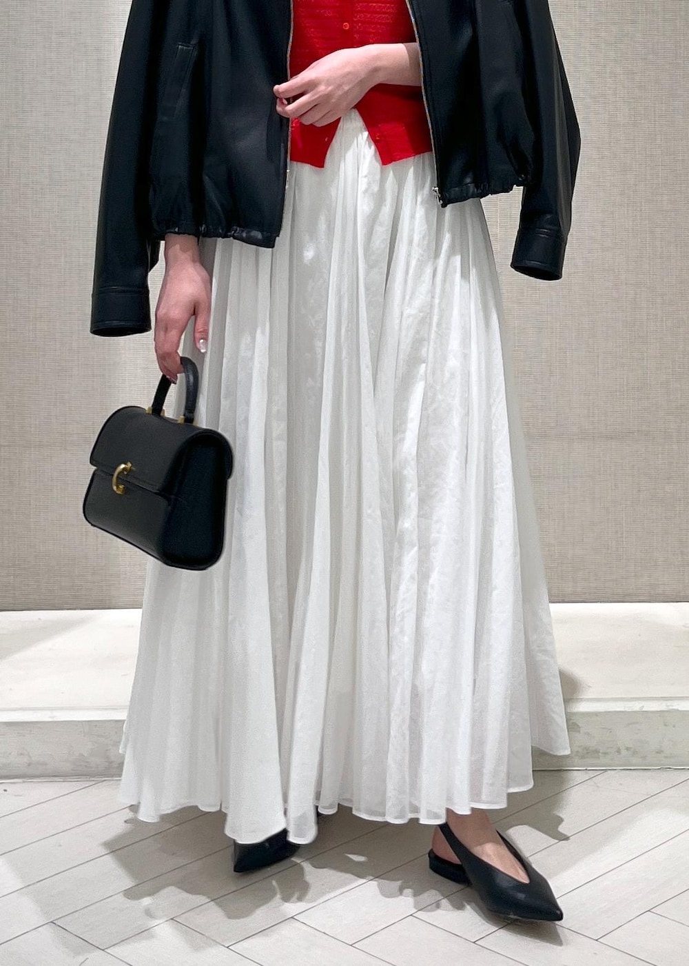 ホワイト系のTシャツ/カットソー、ブラック系のパンプス、ホワイト系のスカートを着用したレディースの春コーディネートの6枚目の写真