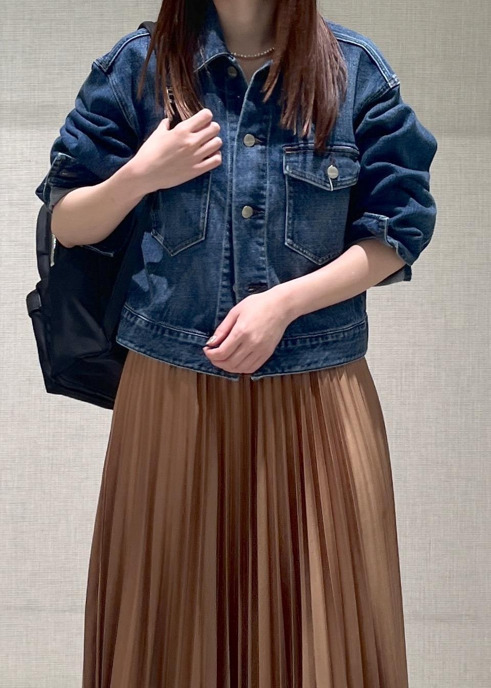 イエロー系のスカート、ブラック系のバックパック/リュック、ブラック系のローファーを着用したレディースの春コーディネートの5枚目の写真