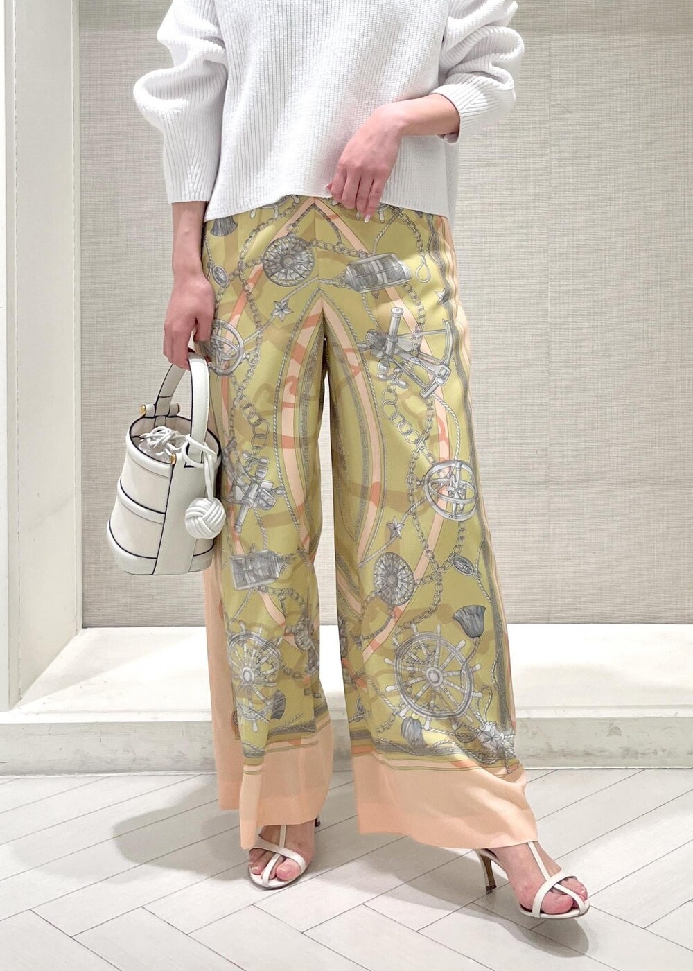 ホワイト系のハンドバッグ、ホワイト系のニット/セーター、イエロー系のその他パンツを着用したレディースの春コーディネートの6枚目の写真