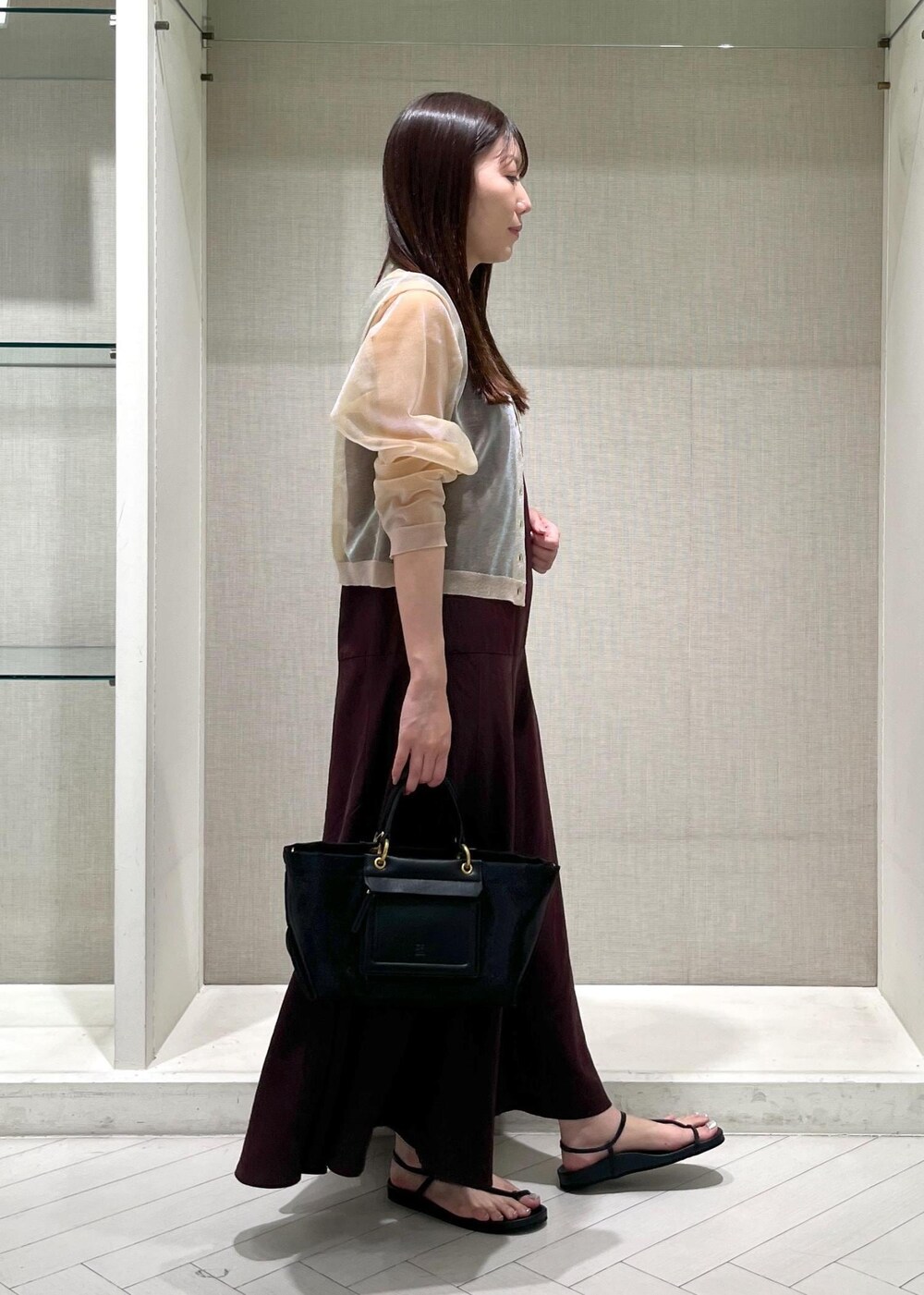 ブラック系のサンダル、ブラウン系のワンピース、ホワイト系のカーディガン/ボレロを着用したレディースの夏コーディネートの2枚目の写真