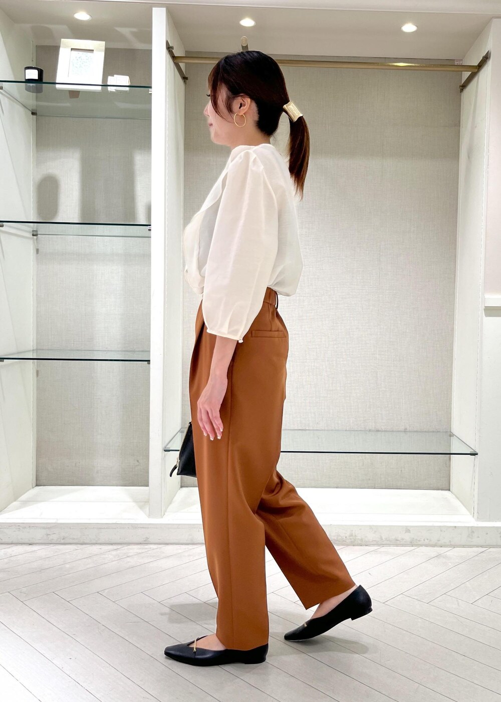 ブラック系のハンドバッグ、ブラック系のパンプス、ホワイト系のシャツ/ブラウスを着用したレディースの秋コーディネートの4枚目の写真