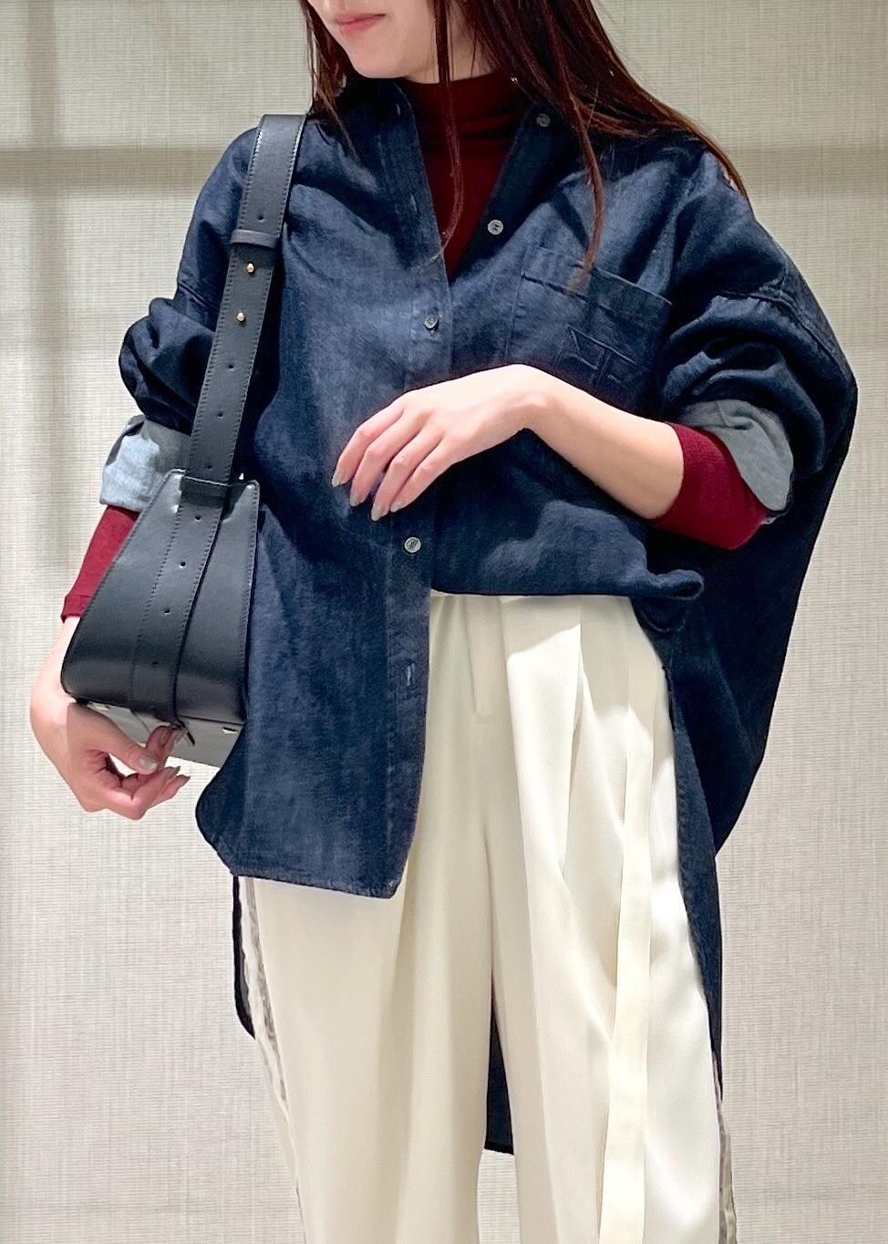 ブルー系のシャツ/ブラウス、ブラック系のハンドバッグ、ブラック系のブーツを着用したレディースの秋コーディネートの6枚目の写真