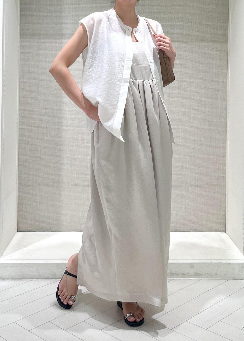 ブラック系のサンダル、ホワイト系のTシャツ/カットソー、ベージュ系のワンピースを着用したレディースの夏コーディネートの4枚目の写真