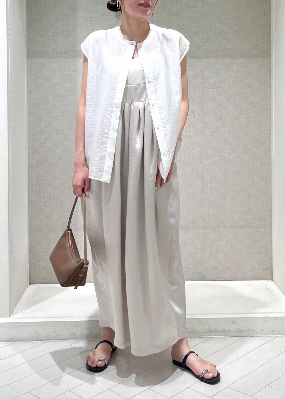 ブラック系のサンダル、ホワイト系のTシャツ/カットソー、ベージュ系のワンピースを着用したレディースの夏コーディネートの6枚目の写真