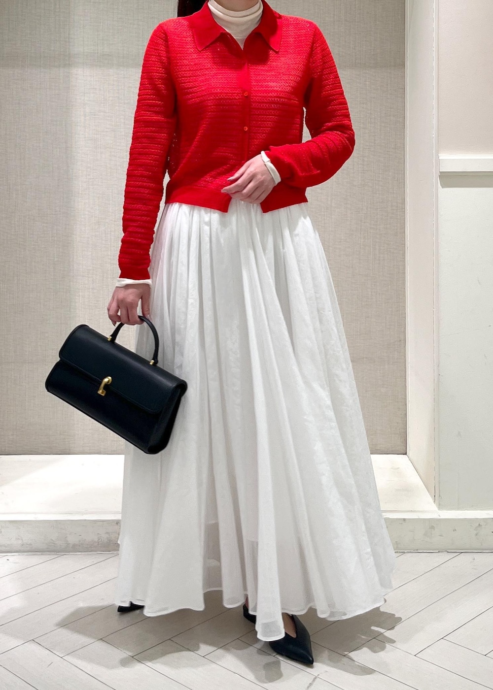 ホワイト系のTシャツ/カットソー、ブラック系のパンプス、ホワイト系のスカートを着用したレディースの春コーディネートの9枚目の写真