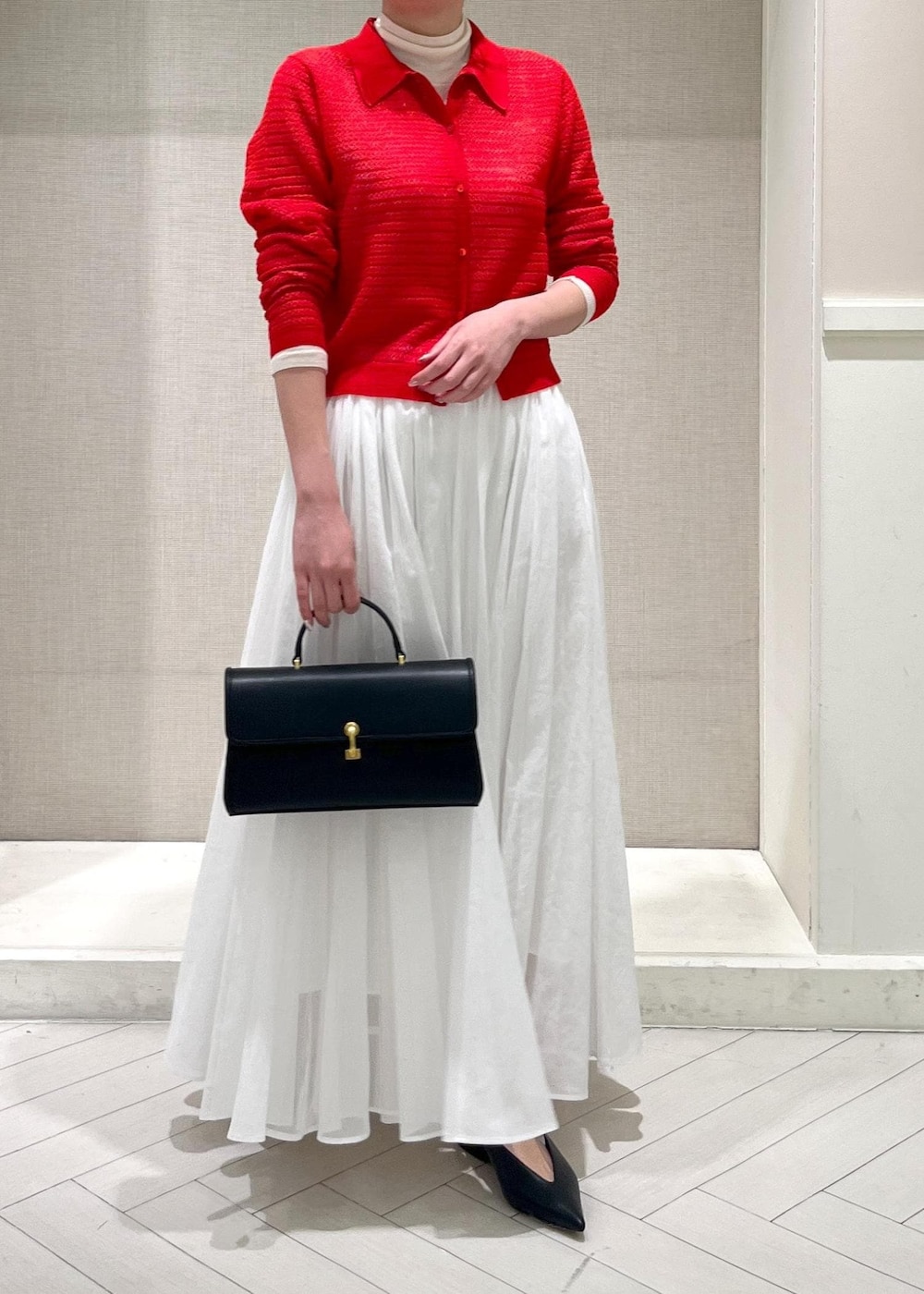 ホワイト系のTシャツ/カットソー、ブラック系のパンプス、ホワイト系のスカートを着用したレディースの春コーディネートの8枚目の写真