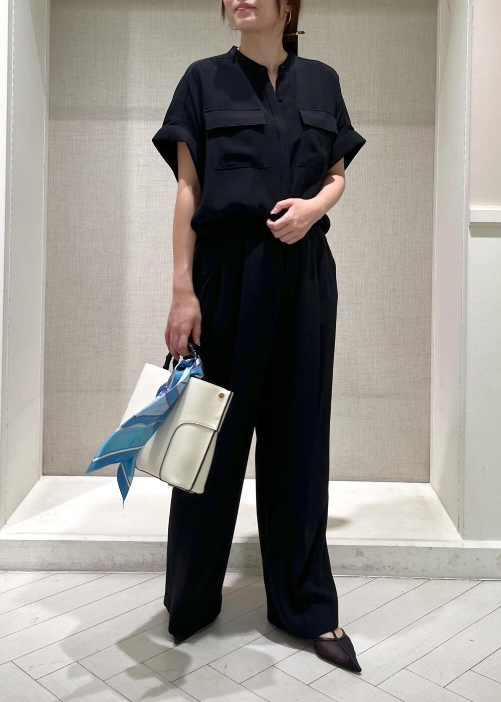 ブラック系のパンプス、ホワイト系のハンドバッグ、ブラック系のシャツ/ブラウスを着用したレディースの秋コーディネートの7枚目の写真