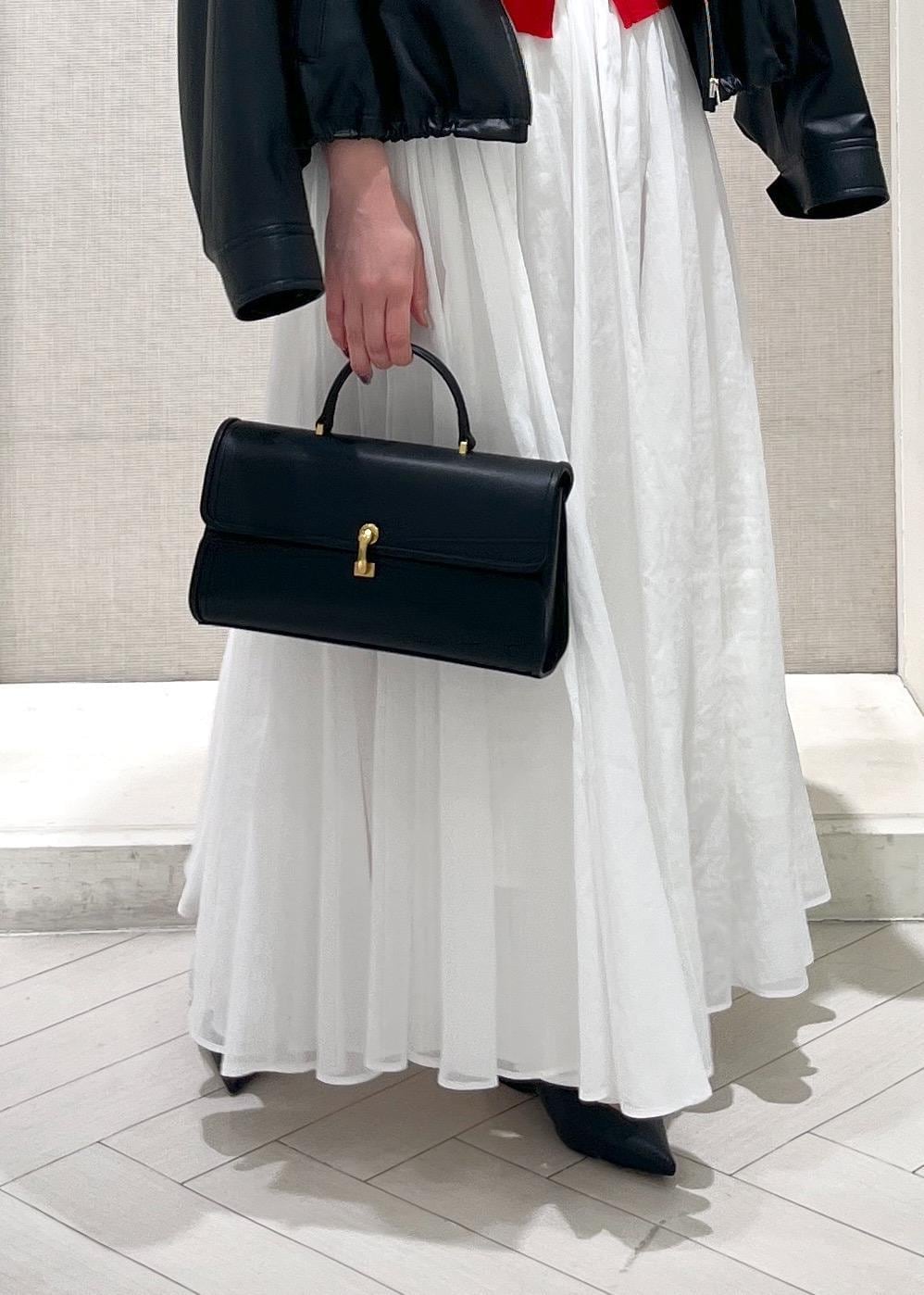 ホワイト系のTシャツ/カットソー、ブラック系のパンプス、ホワイト系のスカートを着用したレディースの春コーディネートの7枚目の写真