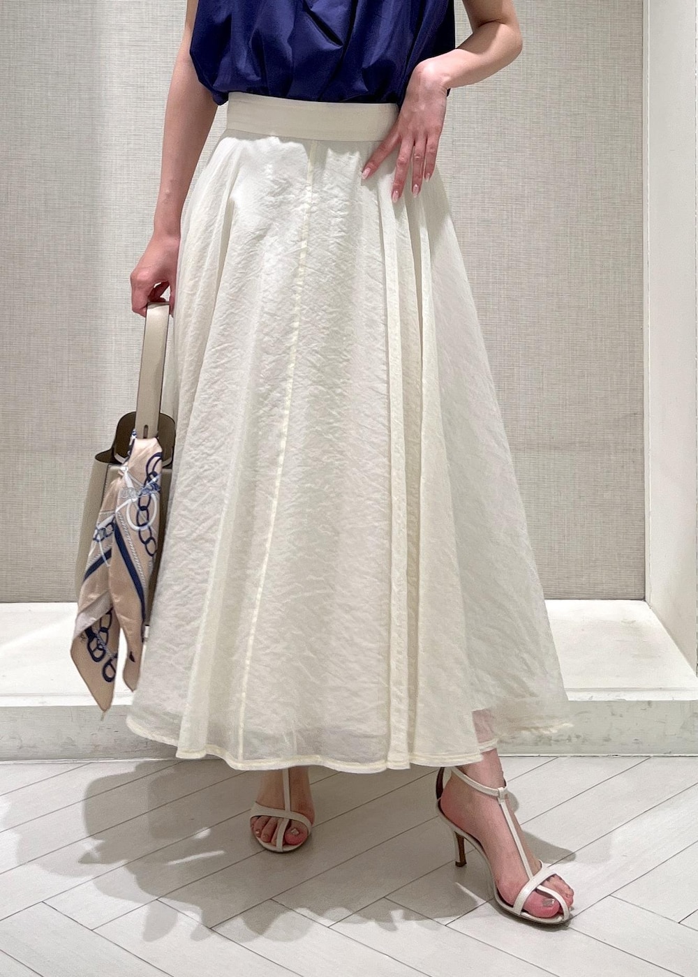 ホワイト系のサンダル、ホワイト系のスカート、ブルー系のシャツ/ブラウスを着用したレディースの春コーディネートの6枚目の写真