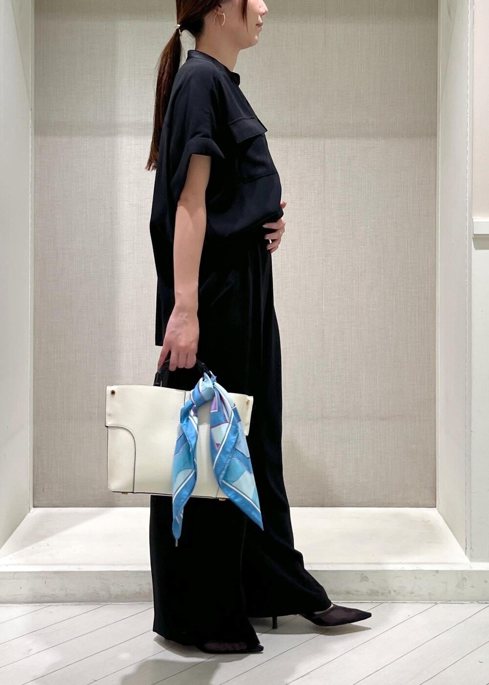 ブラック系のパンプス、ホワイト系のハンドバッグ、ブラック系のシャツ/ブラウスを着用したレディースの秋コーディネートの2枚目の写真