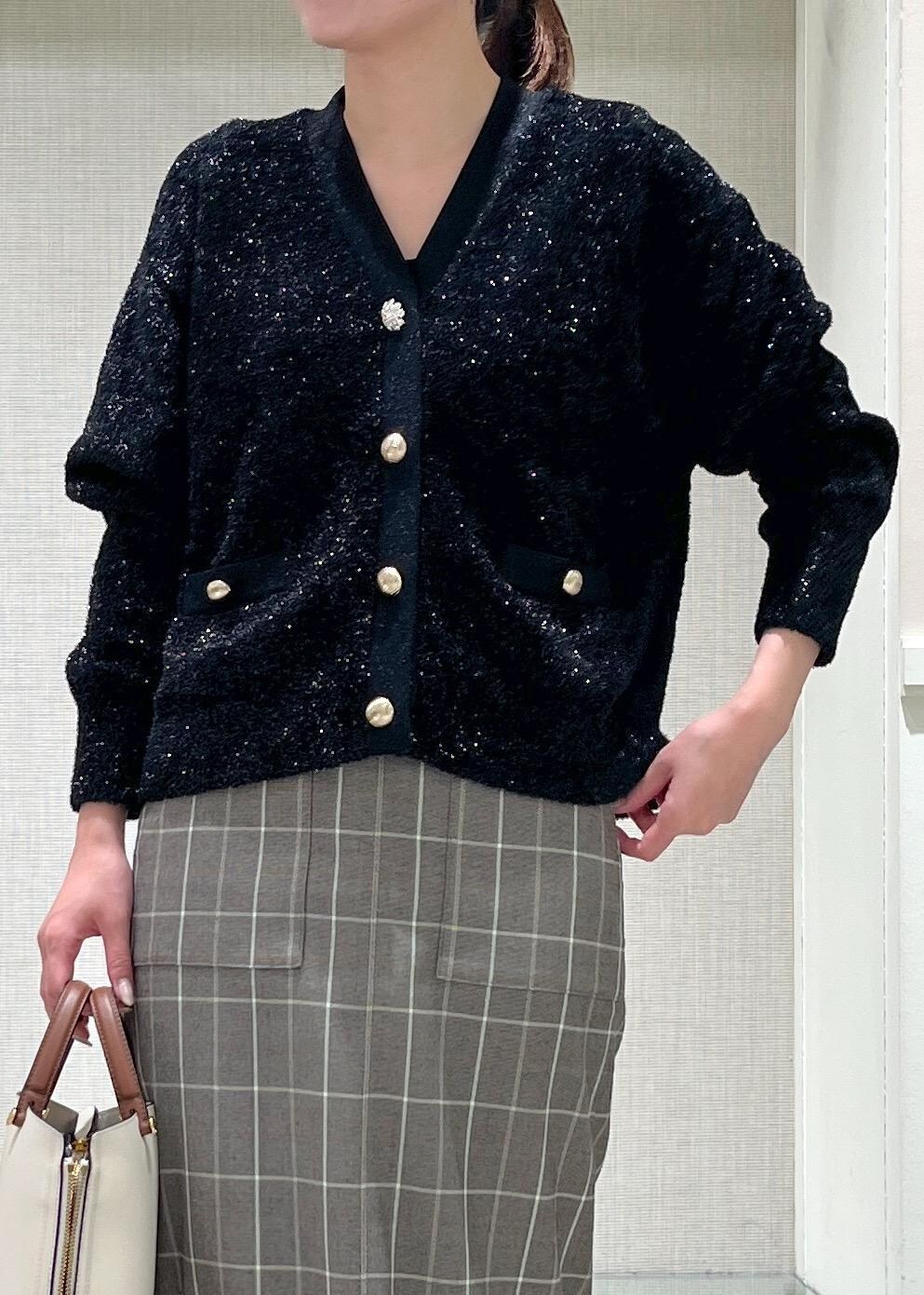 ホワイト系のハンドバッグ、ブラック系のブーツ、ブラウン系のスカートを着用したレディースの秋コーディネートの5枚目の写真