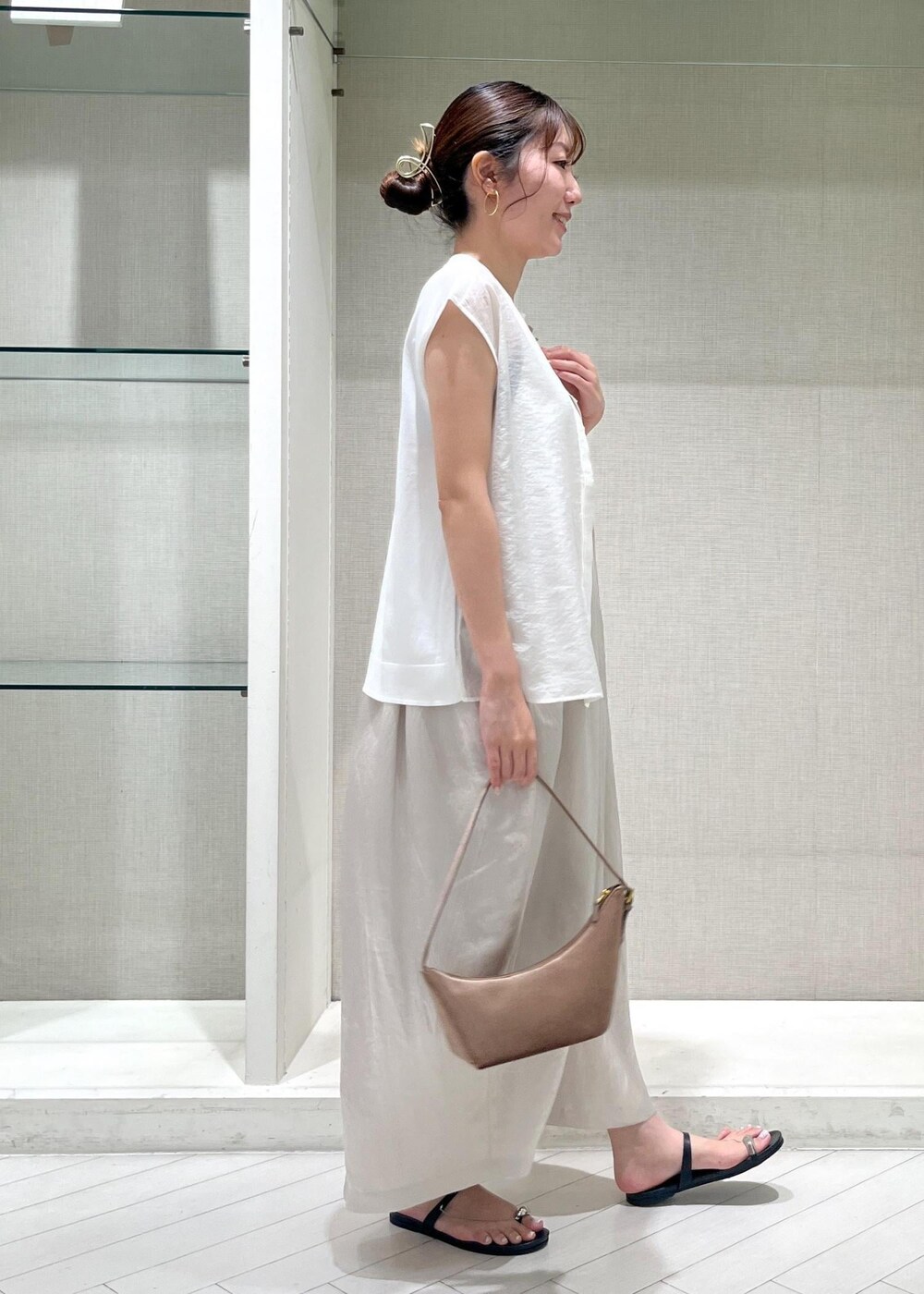 ブラック系のサンダル、ホワイト系のTシャツ/カットソー、ベージュ系のワンピースを着用したレディースの夏コーディネートの2枚目の写真