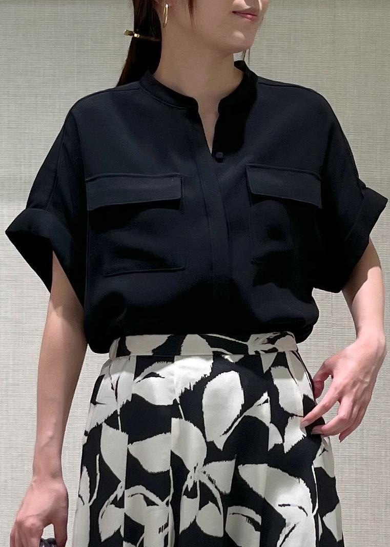 ブラック系のパンプス、パープル系のハンドバッグ、ブラック系のスカートを着用したレディースの秋コーディネートの5枚目の写真