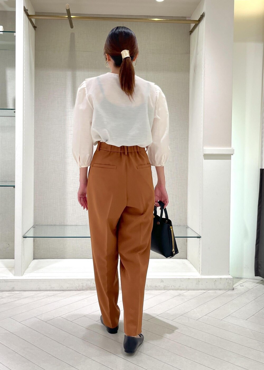 ブラック系のハンドバッグ、ブラック系のパンプス、ホワイト系のシャツ/ブラウスを着用したレディースの秋コーディネートの5枚目の写真