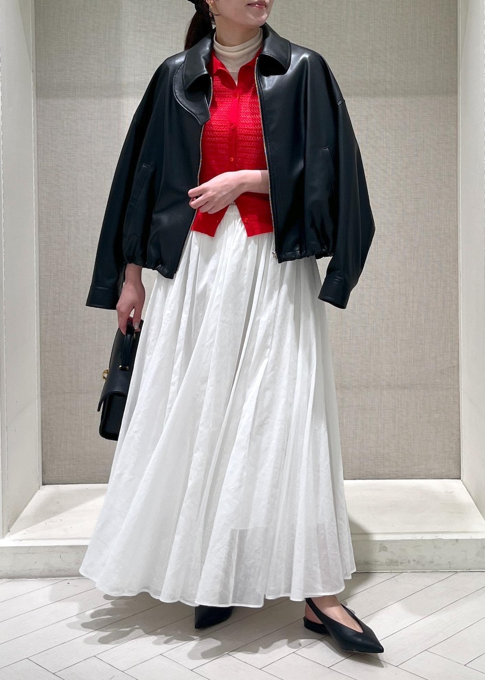 ホワイト系のTシャツ/カットソー、ブラック系のパンプス、ホワイト系のスカートを着用したレディースの春コーディネートの4枚目の写真