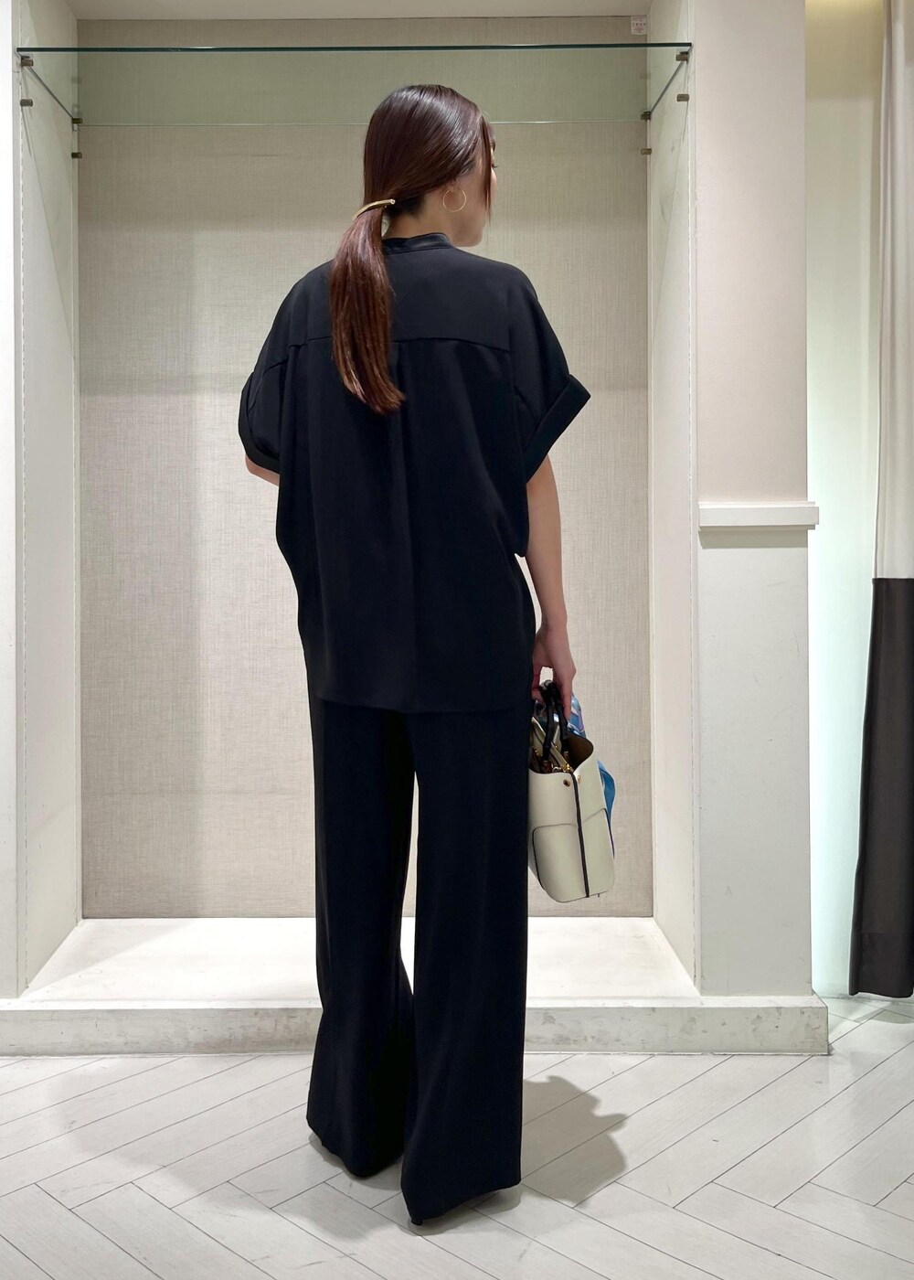 ブラック系のパンプス、ホワイト系のハンドバッグ、ブラック系のシャツ/ブラウスを着用したレディースの秋コーディネートの3枚目の写真