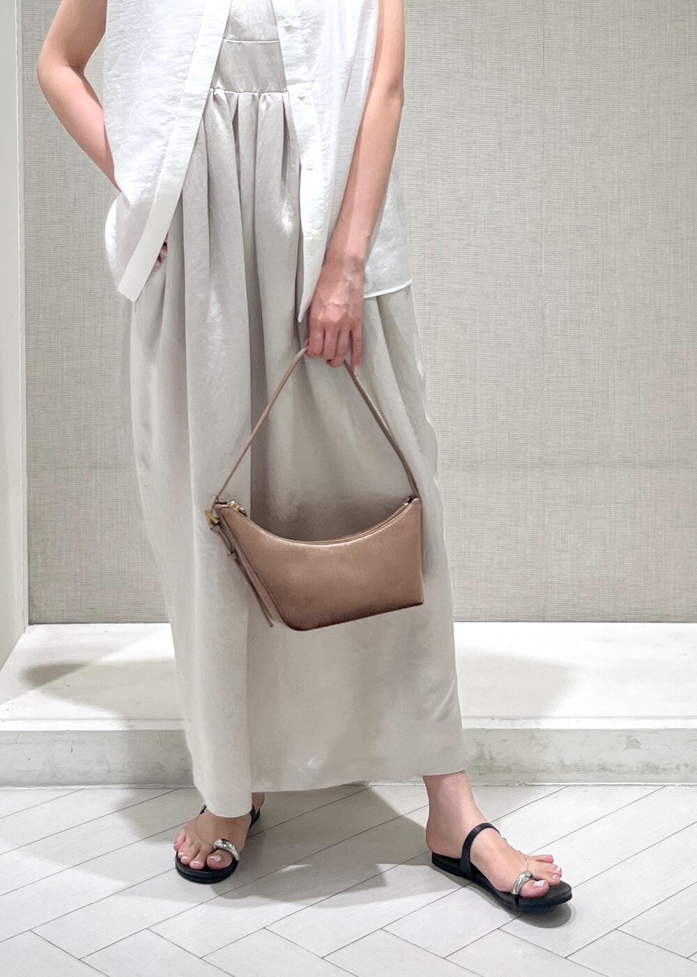 ブラック系のサンダル、ホワイト系のTシャツ/カットソー、ベージュ系のワンピースを着用したレディースの夏コーディネートの7枚目の写真