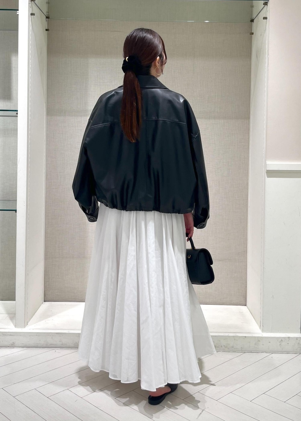 ホワイト系のTシャツ/カットソー、ブラック系のパンプス、ホワイト系のスカートを着用したレディースの春コーディネートの3枚目の写真