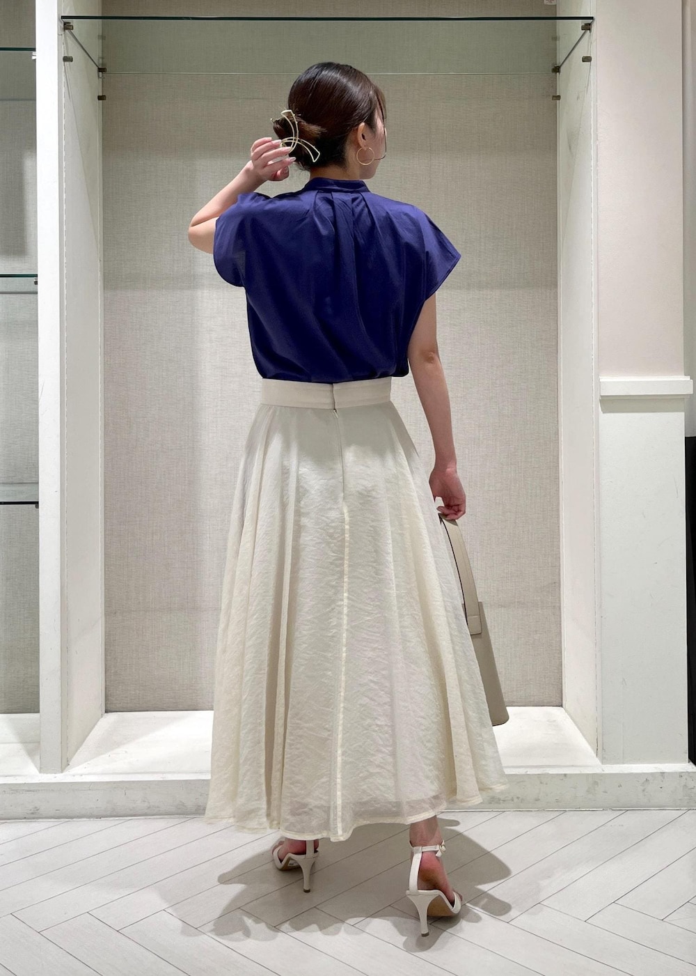 ホワイト系のサンダル、ホワイト系のスカート、ブルー系のシャツ/ブラウスを着用したレディースの春コーディネートの3枚目の写真