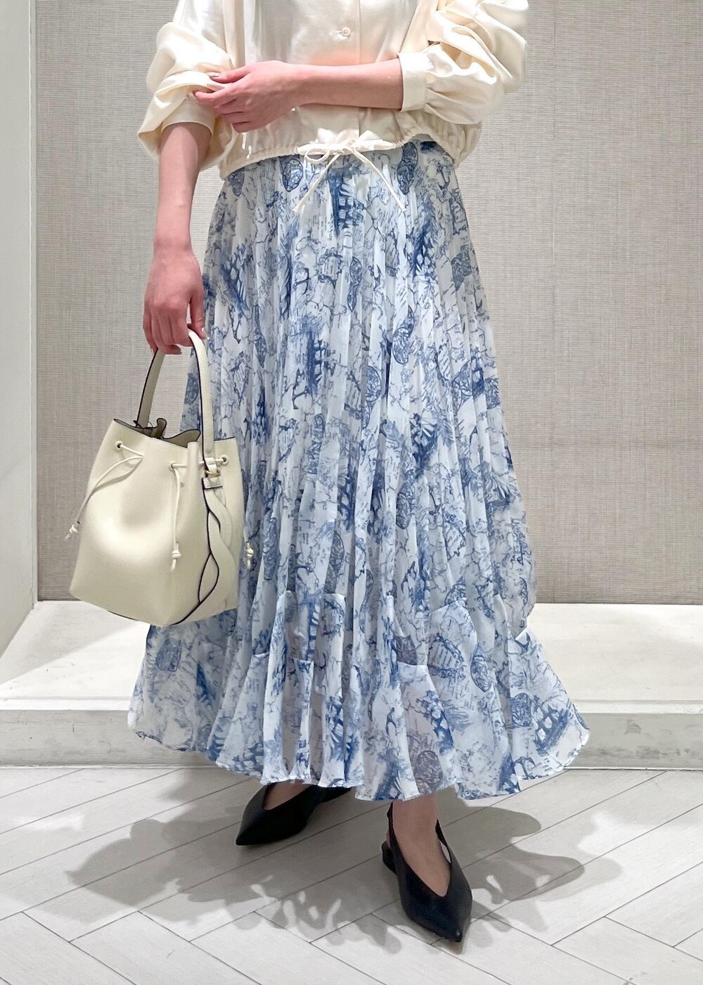 ブラック系のパンプス、ブルー系のスカート、ホワイト系のシャツ/ブラウスを着用したレディースの冬コーディネートの7枚目の写真