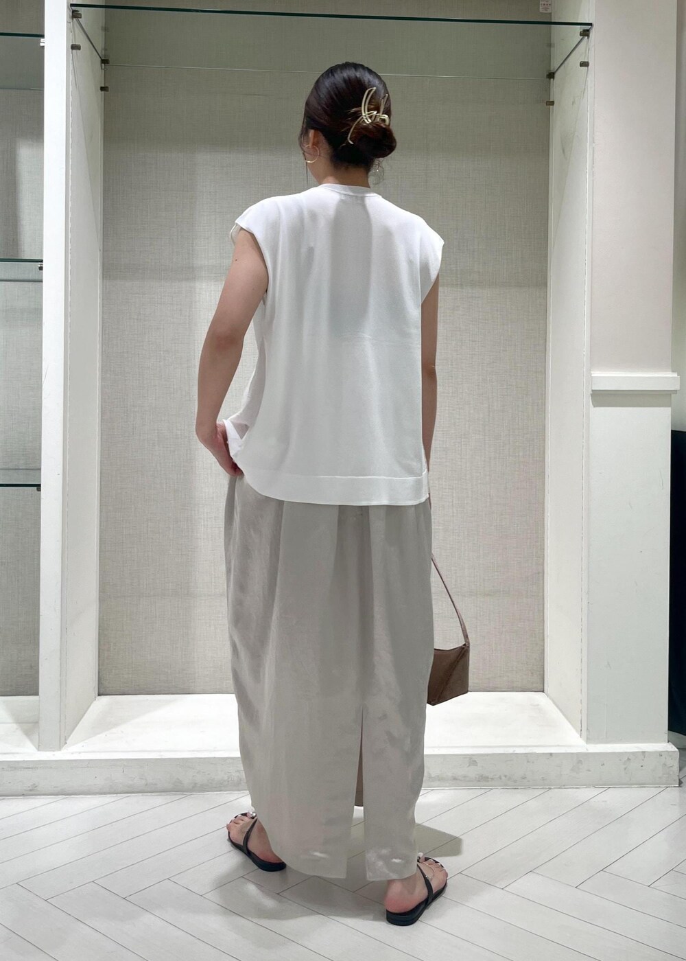 ブラック系のサンダル、ホワイト系のTシャツ/カットソー、ベージュ系のワンピースを着用したレディースの夏コーディネートの3枚目の写真