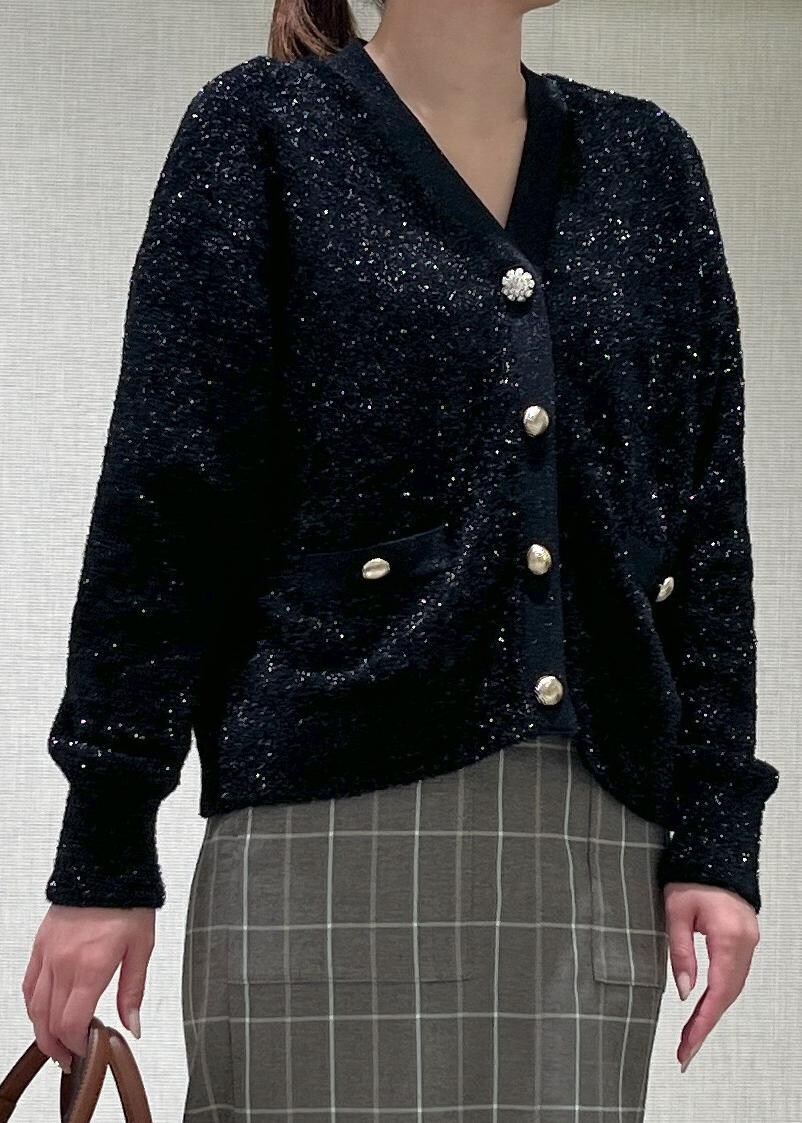 ホワイト系のハンドバッグ、ブラック系のブーツ、ブラウン系のスカートを着用したレディースの秋コーディネートの4枚目の写真