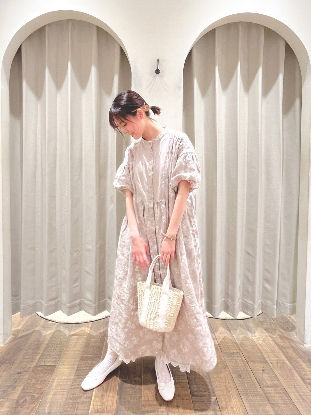 ベージュ系のワンピース、ホワイト系のハンドバッグを着用したレディースの春コーディネートの2枚目の写真