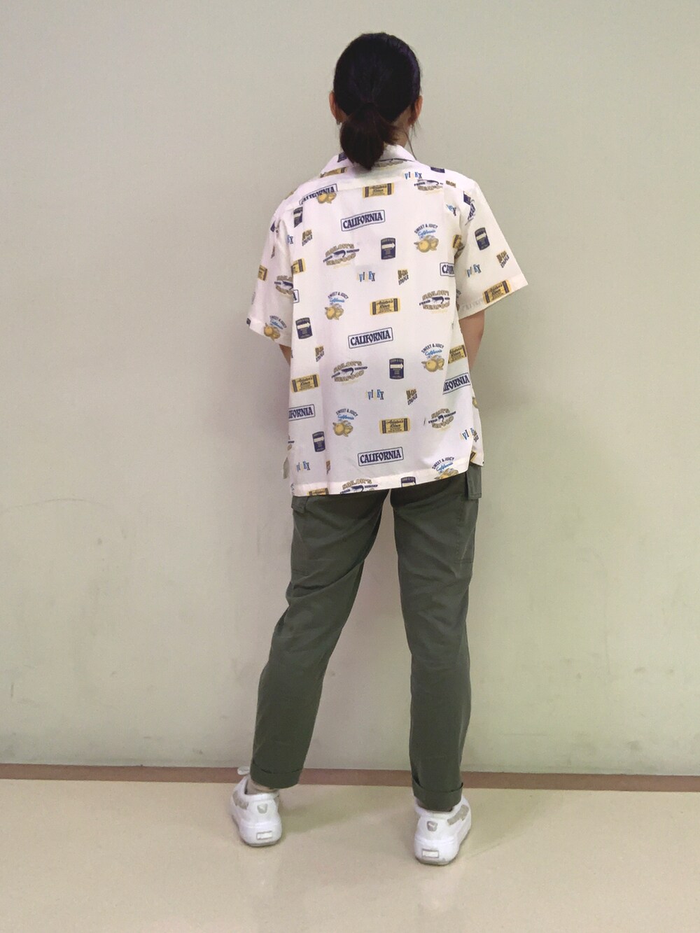 グリーン系のカーゴパンツ、ホワイト系のシャツ/ブラウス、オレンジ系のTシャツ/カットソーを着用したレディースの春コーディネートの2枚目の写真