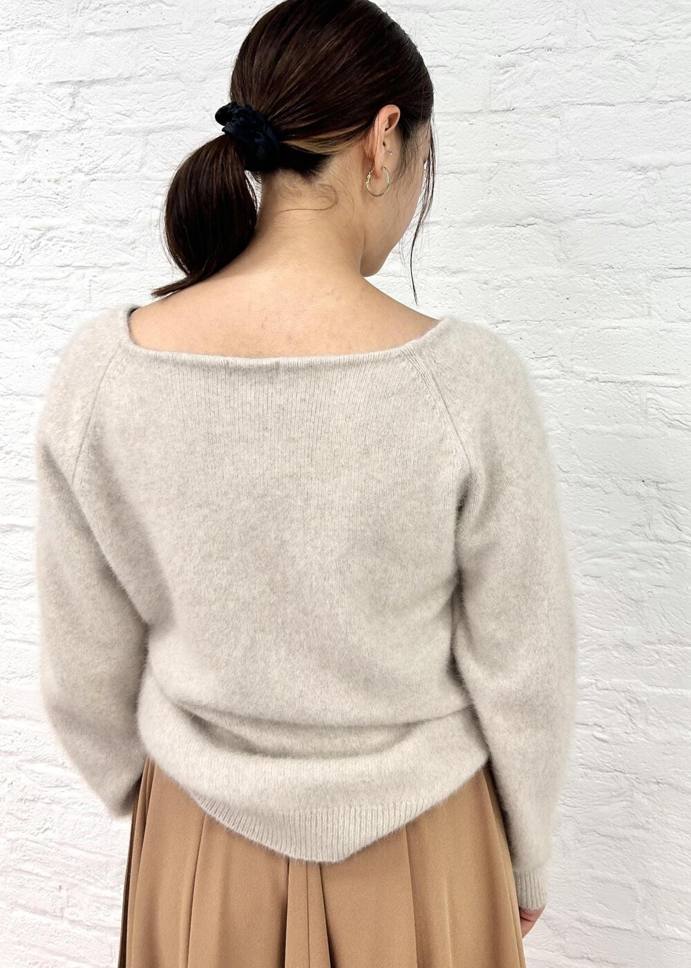 ブラック系のパンプス、ベージュ系のニット/セーター、グリーン系のハンドバッグを着用したレディースの秋コーディネートの8枚目の写真