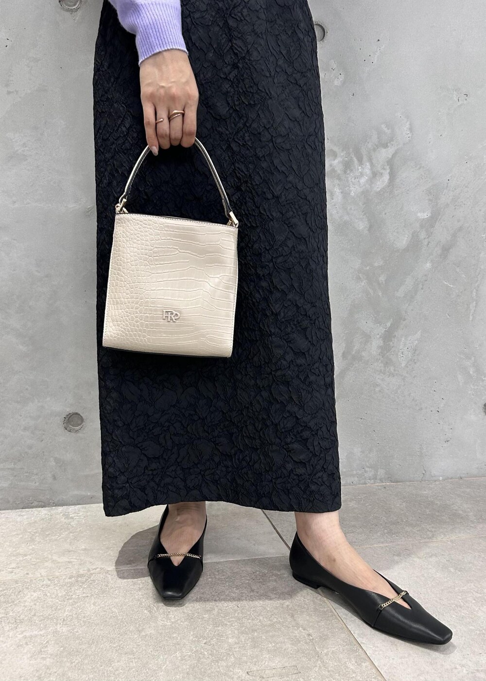 ブラック系のパンプス、ベージュ系のショルダーバッグ、パープル系のニット/セーターを着用したレディースの秋コーディネートの9枚目の写真