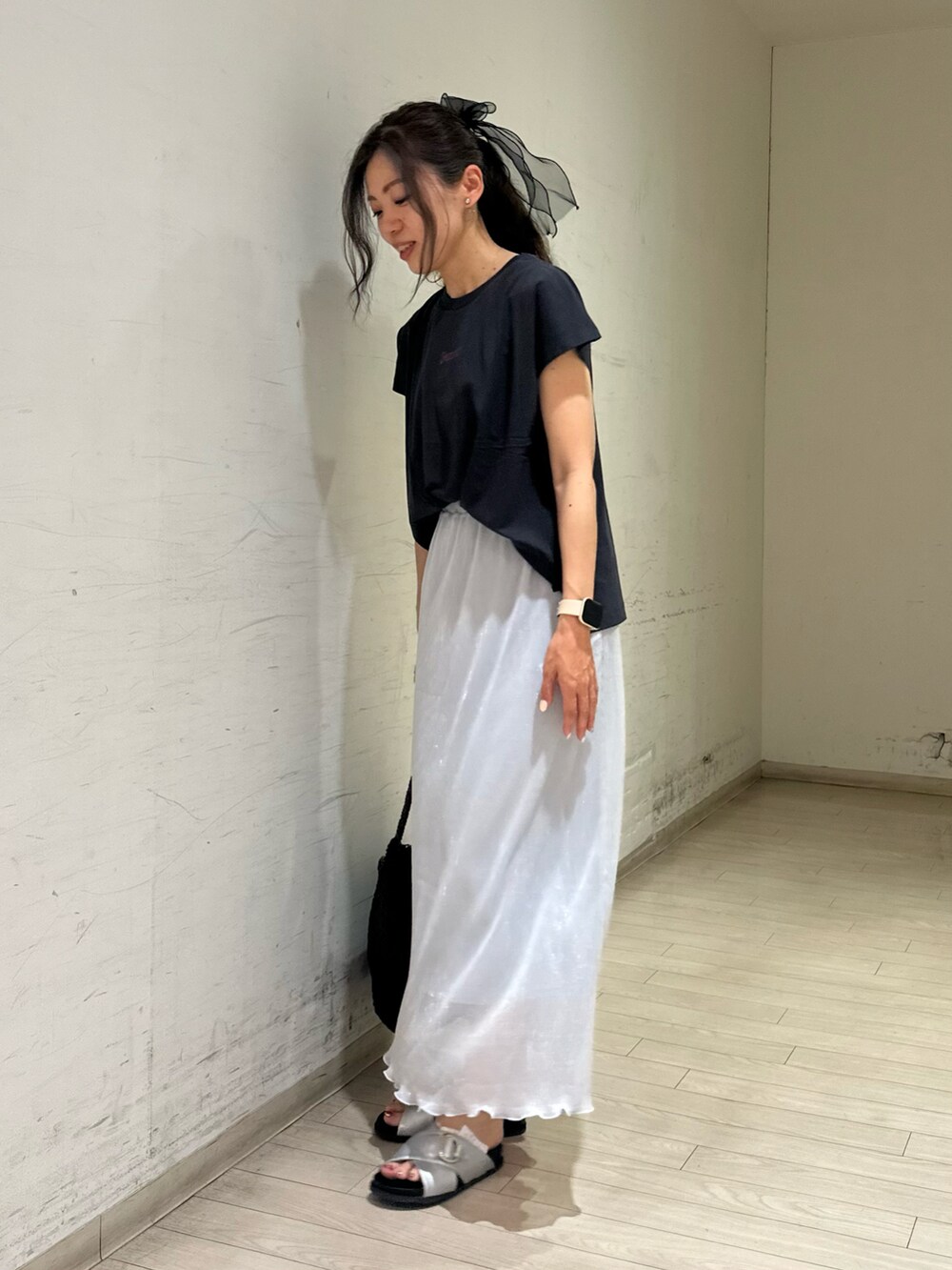 グレー系のTシャツ/カットソー、ブラウン系のハンドバッグ、シルバー系のドレスシューズを着用したレディースの春コーディネートの2枚目の写真