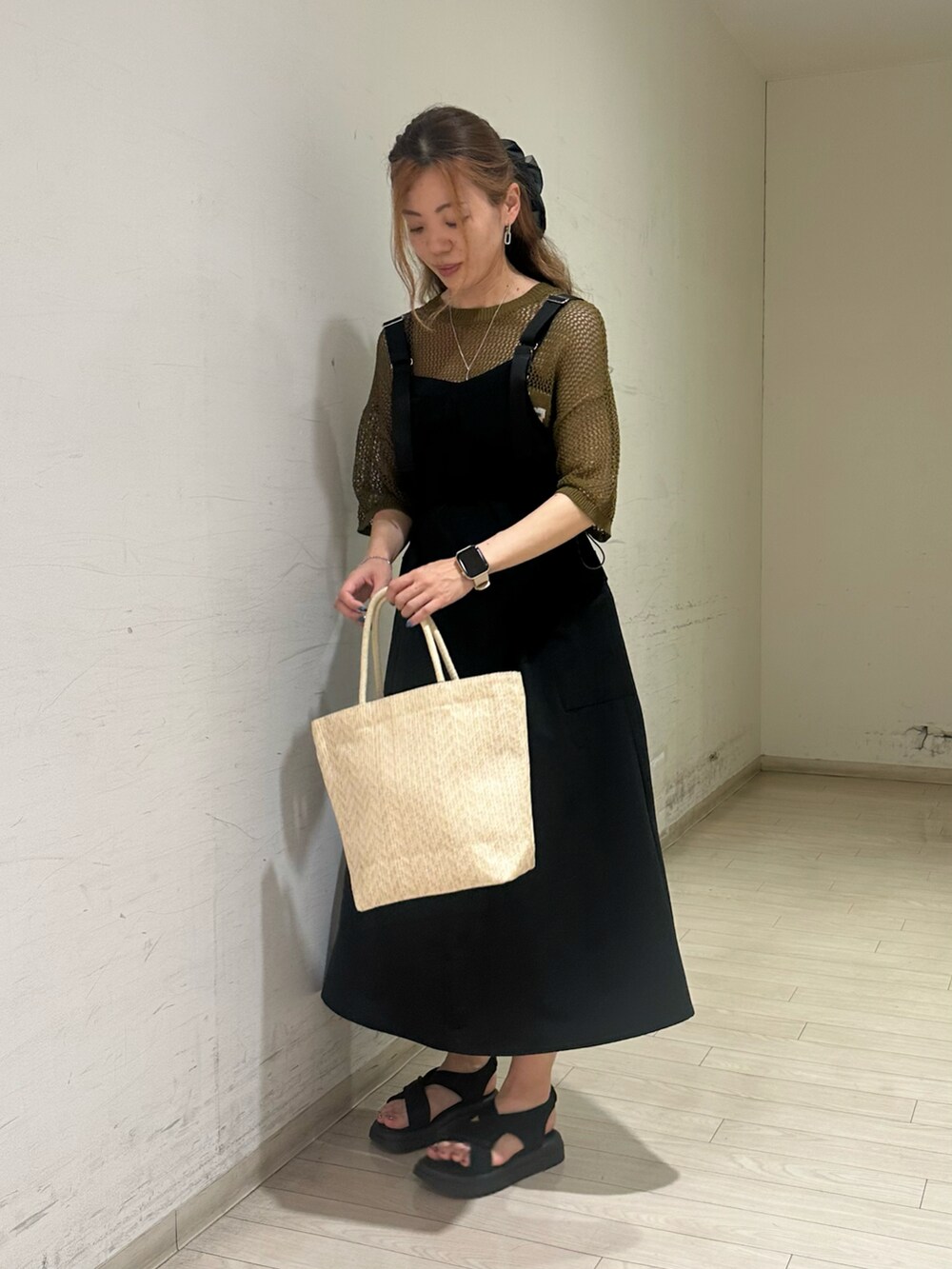 グリーン系のニット/セーター、ホワイト系のハンドバッグ、ブラック系のドレスシューズを着用したレディースの春コーディネートの4枚目の写真