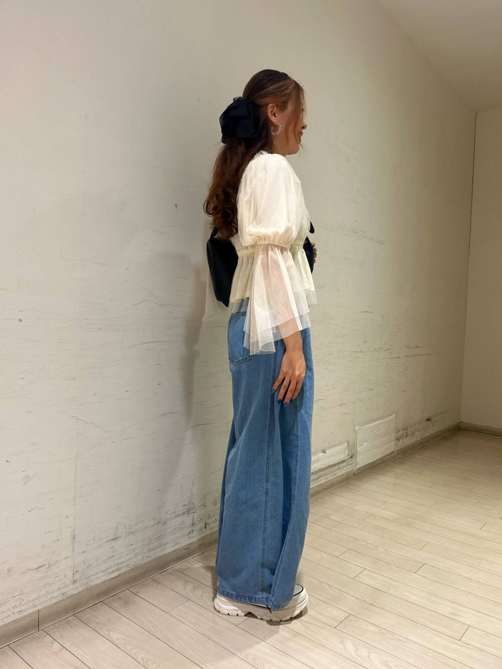 ブラック系のハンドバッグ、ブラウン系のスニーカー、ホワイト系のシャツ/ブラウスを着用したレディースの春コーディネートの3枚目の写真