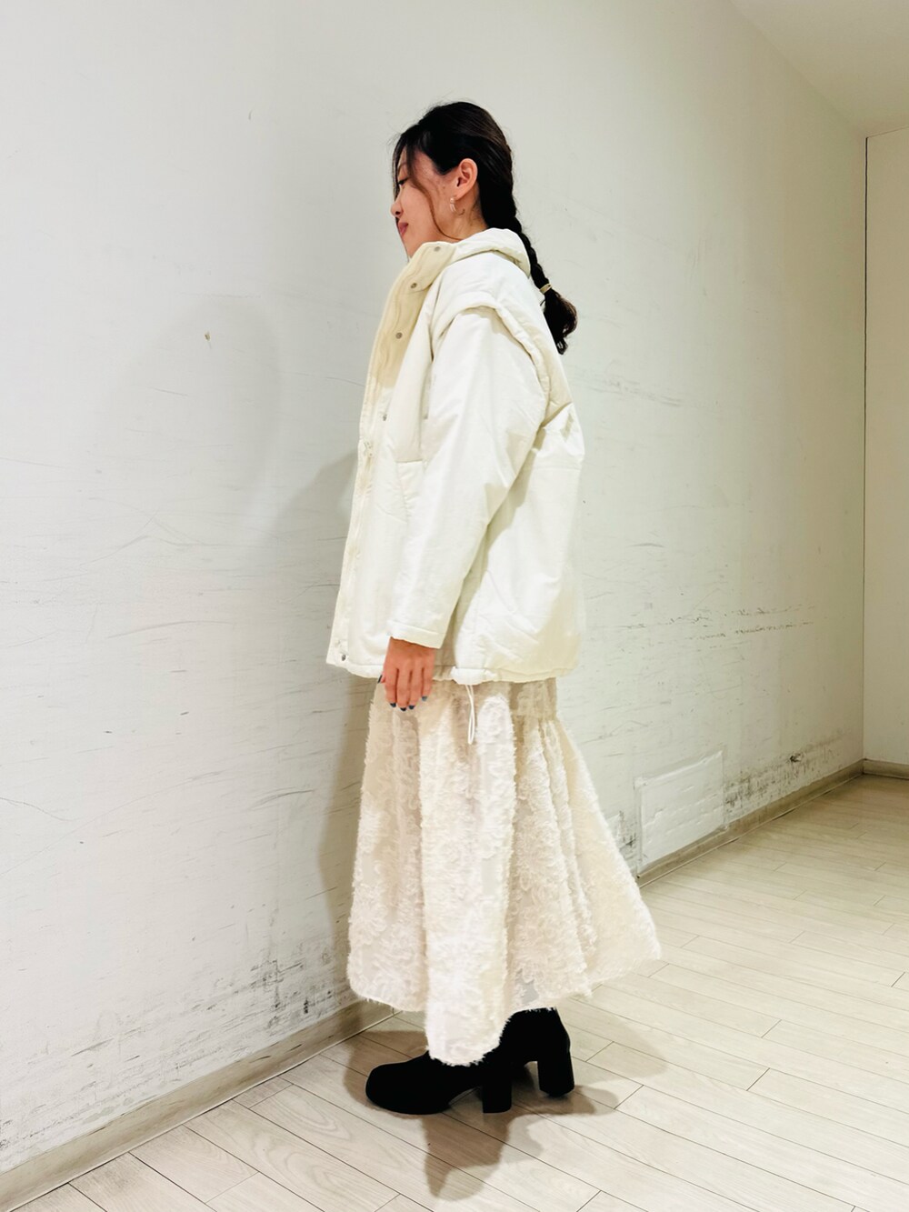 ホワイト系のノーカラージャケット、グレー系のニット/セーター、ホワイト系のスカートを着用したレディースの冬コーディネートの4枚目の写真