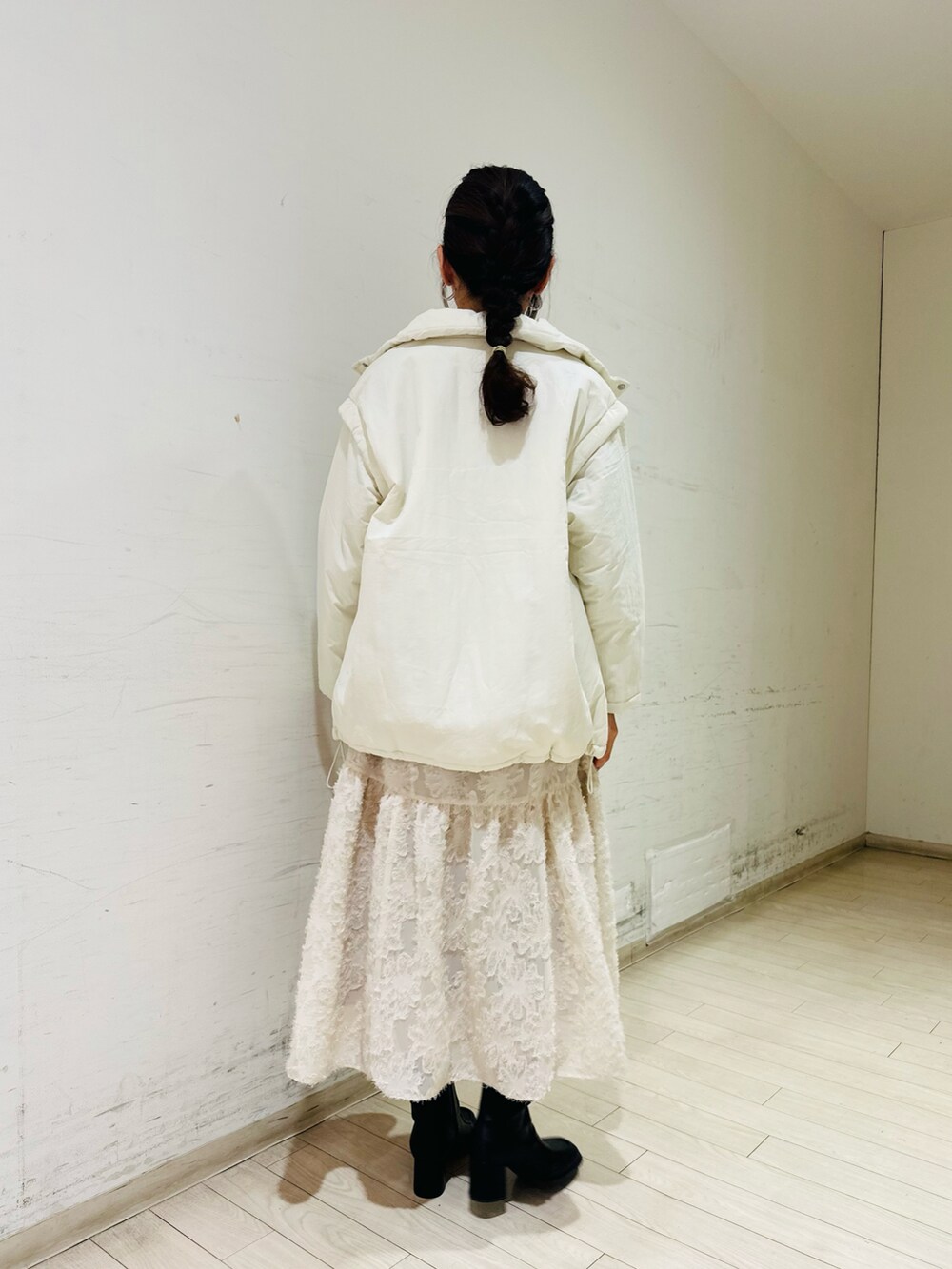 ホワイト系のノーカラージャケット、グレー系のニット/セーター、ホワイト系のスカートを着用したレディースの冬コーディネートの3枚目の写真