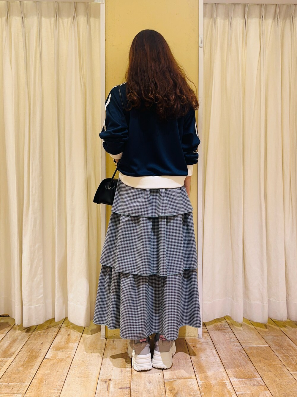 ブルー系のノーカラージャケット、グリーン系のスカート、グレー系のスニーカーを着用したレディースの春コーディネートの3枚目の写真