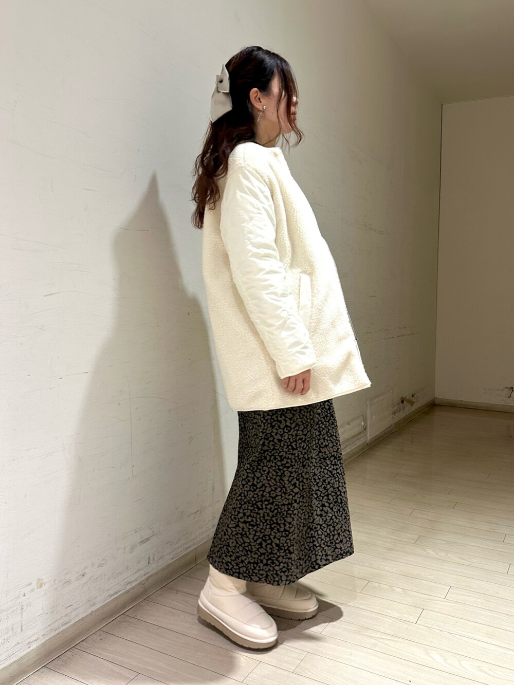 ホワイト系のブルゾン、ブラウン系のニット/セーター、ブラウン系のスカートを着用したレディースの冬コーディネートの2枚目の写真