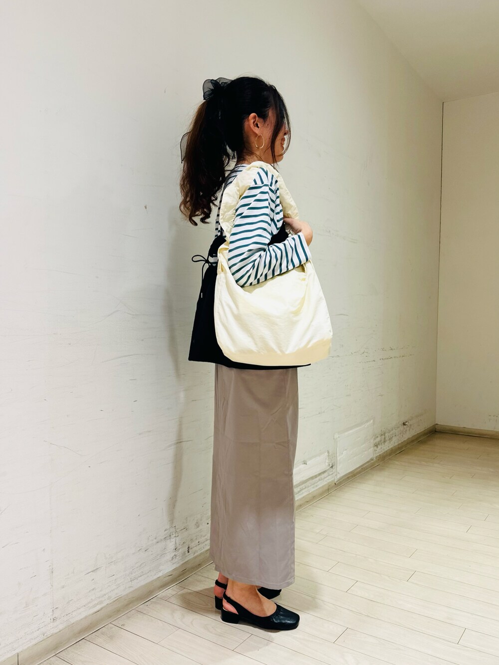 グリーン系のTシャツ/カットソー、ブラック系のシャツ/ブラウス、ホワイト系のハンドバッグを着用したレディースの春コーディネートの2枚目の写真