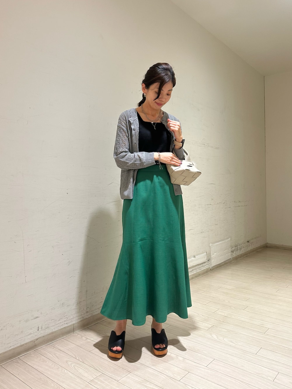 グレー系のカーディガン/ボレロ、ブラック系のTシャツ/カットソー、グリーン系のスカートを着用したレディースの春コーディネートの2枚目の写真