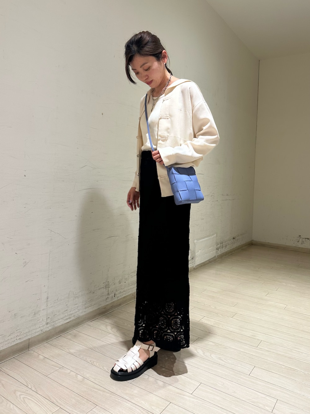 ホワイト系のシャツ/ブラウス、ホワイト系のタンクトップ、ブルー系のショルダーバッグを着用したレディースの春コーディネートの2枚目の写真