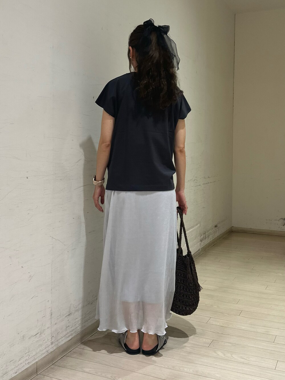 グレー系のTシャツ/カットソー、ブラウン系のハンドバッグ、シルバー系のドレスシューズを着用したレディースの春コーディネートの3枚目の写真