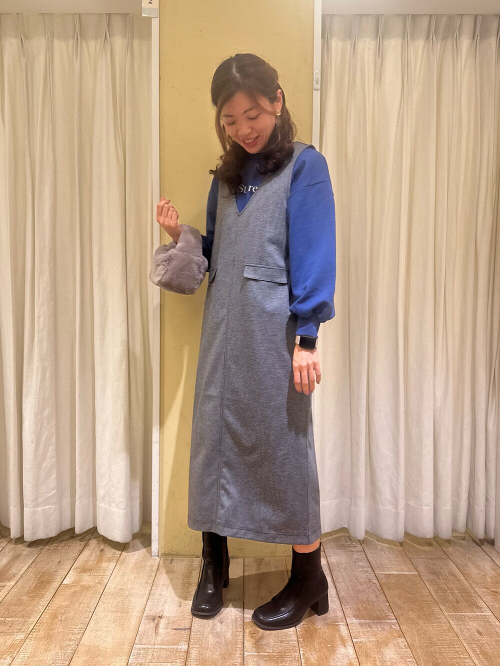 グレー系のワンピース、ブラック系のドレスシューズ、グレー系のハンドバッグを着用したレディースの秋コーディネートの2枚目の写真