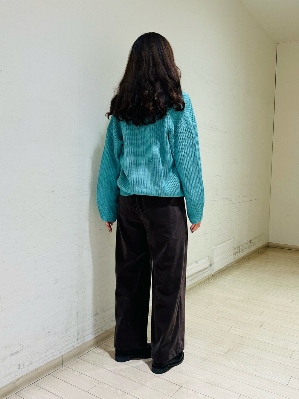 ホワイト系のTシャツ/カットソー、グレー系のその他パンツ、ブラック系のブーツを着用したレディースの冬コーディネートの2枚目の写真