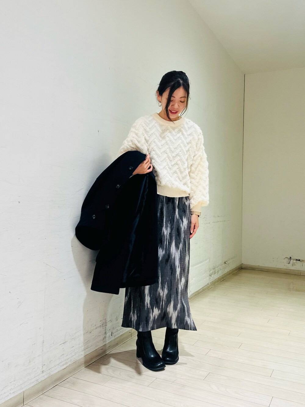 ブルー系のステンカラーコート、ホワイト系のニット/セーター、ブラック系のドレスシューズを着用したレディースの冬コーディネートの3枚目の写真