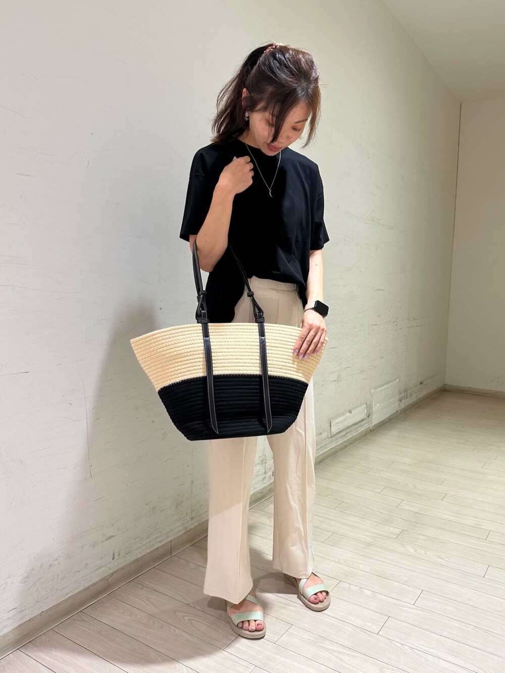 ブラック系のTシャツ/カットソー、ホワイト系のその他パンツ、ホワイト系のハンドバッグを着用したレディースの春コーディネートの3枚目の写真