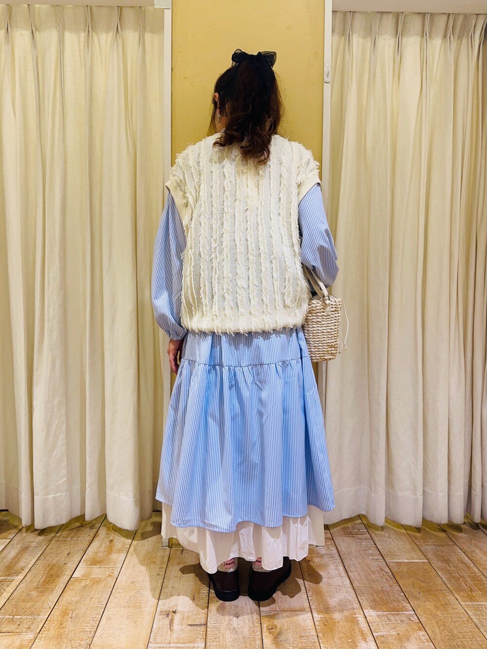 ブルー系のワンピース、ホワイト系のハンドバッグ、ホワイト系のスカートを着用したレディースの春コーディネートの3枚目の写真