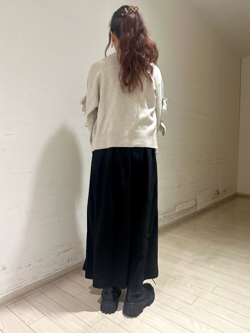 ホワイト系のトップス、グレー系のワンピース、ブラック系のハンドバッグを着用したレディースの冬コーディネートの3枚目の写真