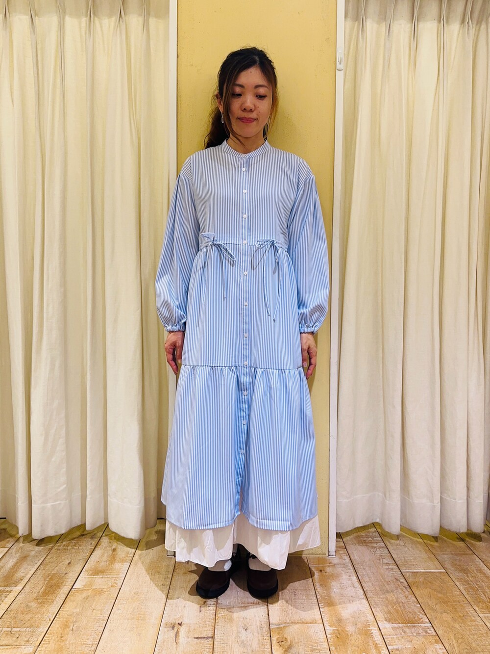 ブルー系のワンピース、ホワイト系のハンドバッグ、ホワイト系のスカートを着用したレディースの春コーディネートの4枚目の写真